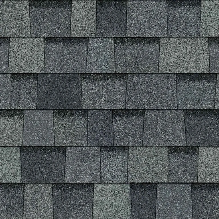 Close-up view of a roof with grey asphalt shingles arranged in a shingle pattern.