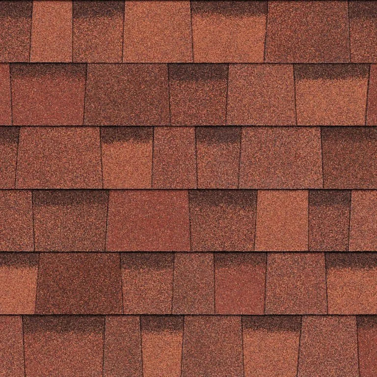Close-up of a roof with red asphalt shingles arranged in a overlapping pattern.