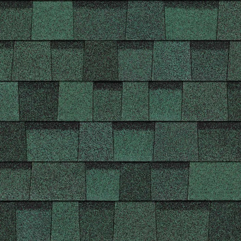 Close-up view of green asphalt shingles on a roof.